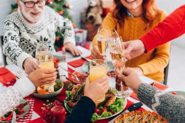 Selective focus of happy family toasting while sitting at festive table at home clipart