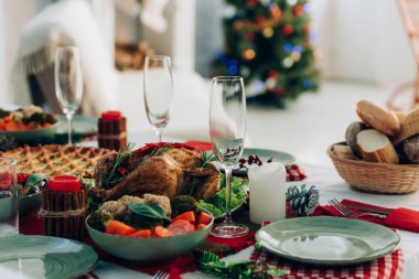 Selective focus of festive table with baked turkey, pie and vegetables clipart