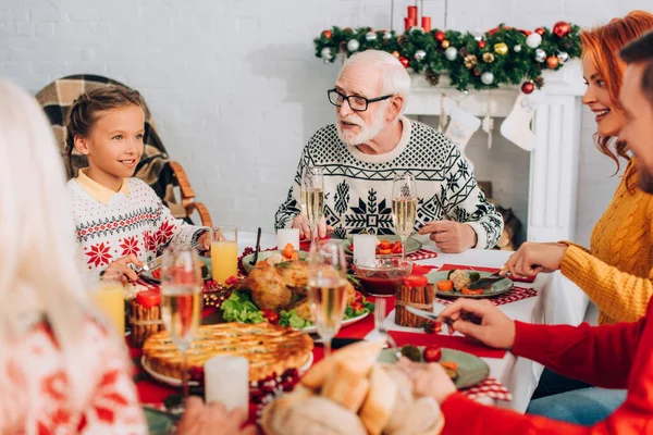 Foco Seletivo Família Feliz Sentado Mesa Festiva Perto Lareira Decorada — Fotografia de Stock