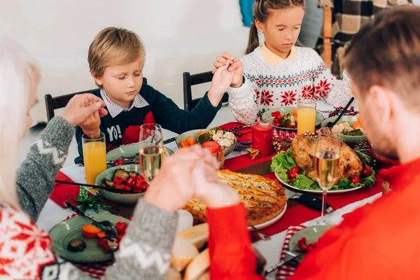 テーブルで手を取り合っている子供たちと家族の選択的な焦点 — ストック写真