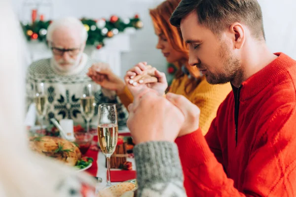 お祝いのテーブルに座っている間に家族と手を取り合う男の選択的な焦点 — ストック写真