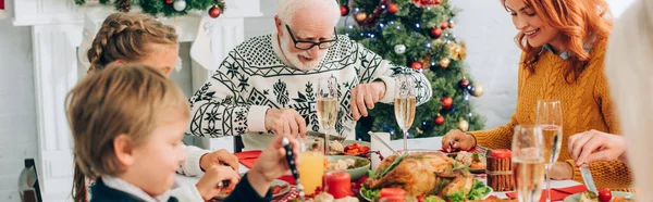 家族の話のパノラマショットと感謝祭の夕食を食べ テーブルに座って — ストック写真