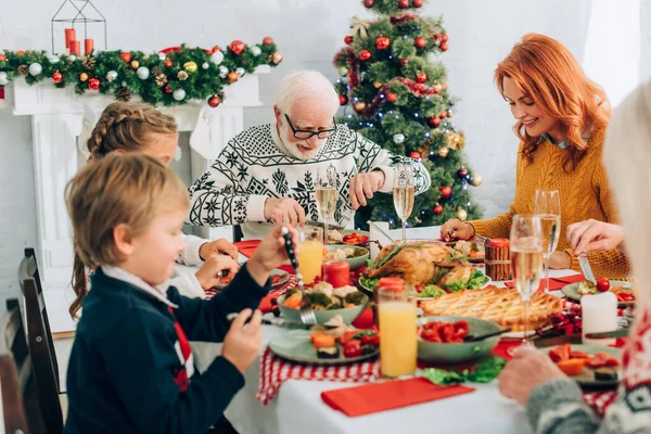 家族と話して家で夕食を食べる祖父の選択的な焦点 — ストック写真
