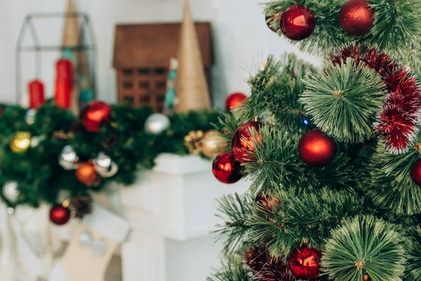 Selective focus of pine branches with christmas balls near decorated fireplace — Stock Image Selective Focus Pine Branches Christmas Balls Decorated Fireplace Royalty Free Stock Photos