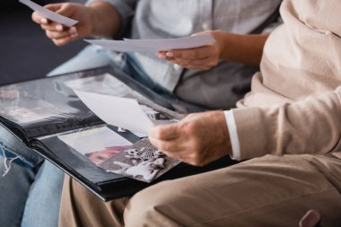 Yaşlı baba ve yetişkin kızın bulanık arka planda aile fotoğraflarına bakması.