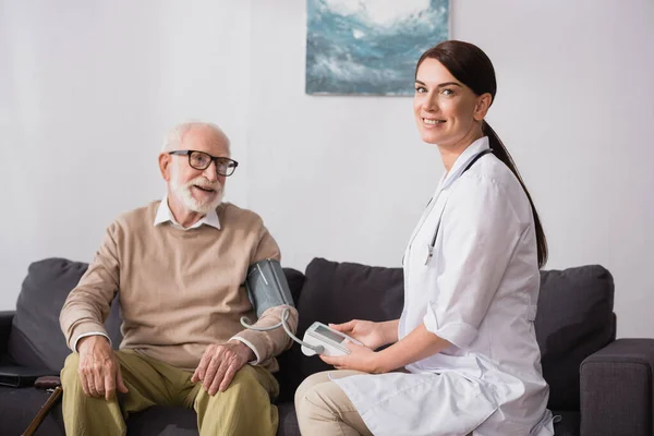 Asistentă Medicală Geriatrică Care Examinează Bărbat Vârstă Tonometru Acasă — Fotografie, imagine de stoc