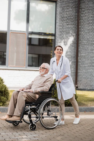 Smiling Social Worker Looking Camera While Walking Handicapped Disabled Man — Stock Photo, Image