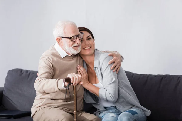 Vděčný Starší Muž Objímání Geriatrický Zdravotní Sestra Zatímco Sedí Pohovce — Stock fotografie