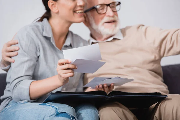 Smiling Woman Looking Photos While Sitting Aged Father Blurred Background — Stock Photo, Image