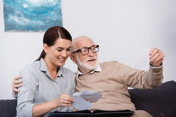 Donna Sorridente Con Padre Anziano Guardando Foto Famiglia Insieme Casa — Foto Stock