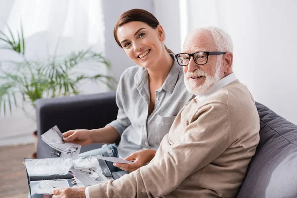 Smiling Woman Elderly Father Looking Camera While Looking Family Photos — Stock Photo, Image