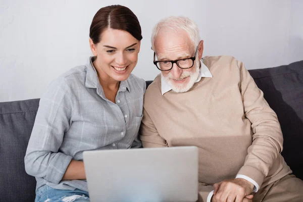 Femme Souriante Avec Père Concentré Utilisant Ordinateur Portable Ensemble Maison — Photo