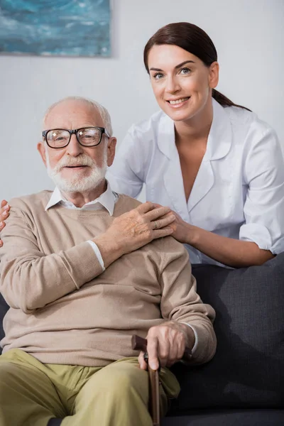 Socialarbetare Hålla Händer Och Omfamna Äldre Man Medan Tittar Kameran — Stockfoto