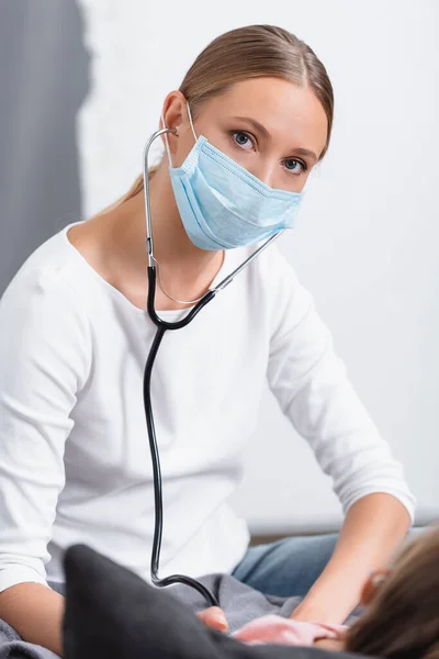 Focus Selettivo Della Donna Maschera Medica Utilizzando Stetoscopio Vicino Bambino — Foto Stock