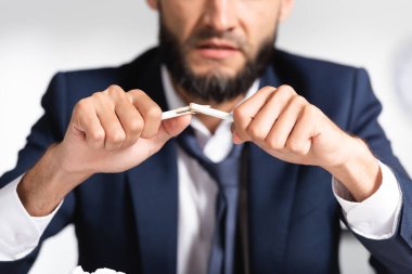 broken pencil in hands of stressed businessman on blurred background  clipart