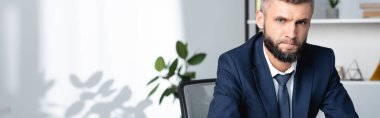 Ofisteki kameraya bakan sakallı işadamı, afiş 