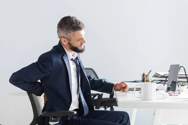 Empresario Que Sufre Dolor Espalda Cerca Gadgets Papelería Mesa Trabajo —  Fotos de Stock