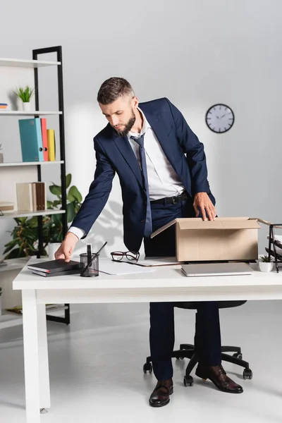 Entlassener Geschäftsmann Nimmt Notizbuch Der Nähe Von Laptop Und Karton — Stockfoto