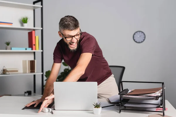 Homem Negócios Irritado Jogando Laptop Artigos Papelaria Mesa Durante Colapso — Fotografia de Stock