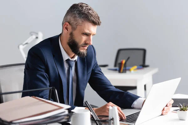 Businessman Using Laptop Documents Cup Blurred Foreground Office — Stock Photo, Image