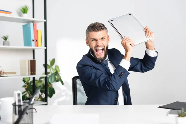 Irradiated Screaming Businessman Holding Laptop Stationery Blurred Foreground Office — Stock Photo, Image