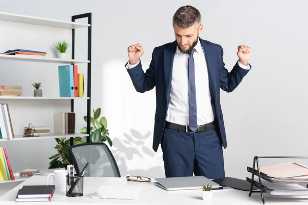 Zakenman Stretching Buurt Van Gadgets Papieren Werktafel — Stockfoto