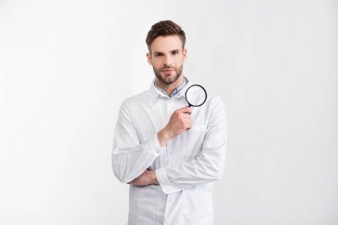 Loupe 'un beyaz önlüklü göz doktoru beyaz önlüklü kameraya bakıyor.