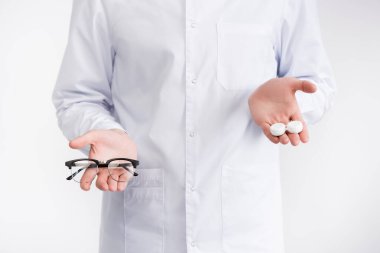 Avuç içi lenslerini beyaz gözlüklerden daha yüksek tutan göz doktorunun kırpılmış görüntüsü