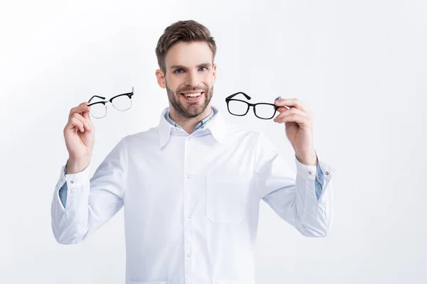 Främre Leende Ögonläkare Visar Par Glasögon Medan Tittar Kameran Isolerad — Stockfoto