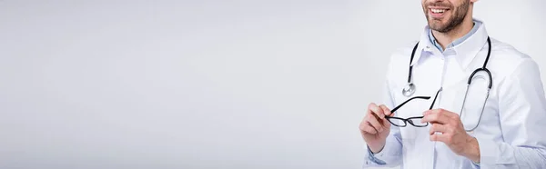 Обрізаний Вид Усміхненого Лікаря Стетоскопом Тримає Окуляри Сірому Фоні Банер — стокове фото