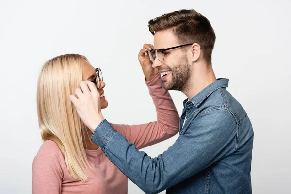 Sonriente Pareja Tocando Los Anteojos Uno Del Otro Aislado Gris — Foto de Stock