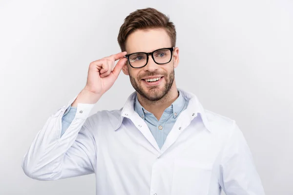 Χαμογελαστή Γιατρός Λευκό Παλτό Αγγίζοντας Γυαλιά Που Απομονώνονται Γκρι — Φωτογραφία Αρχείου