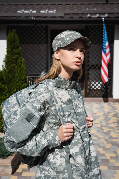 Femeie Militara Adulta Rucsac Uitandu Departe Stand Langa Casa Steag — Fotografie, imagine de stoc