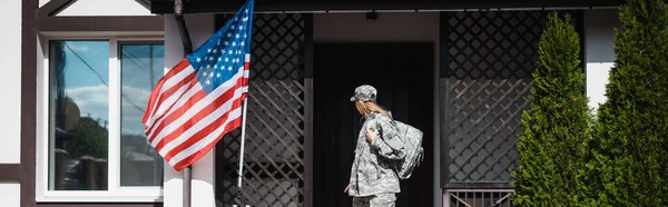 Militær Tjenestekvinne Med Ryggsekk Forlater Huset Står Terskel Banner – stockfoto