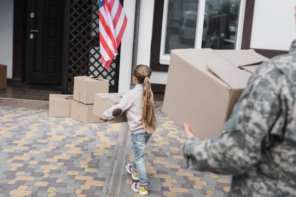 Visão Traseira Menina Transportando Caixa Papelão Perto Casa Com Pai — Fotografia de Stock