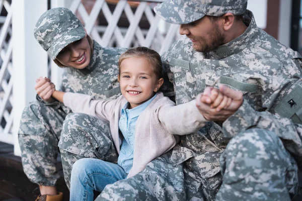 Lykkelig Datter Med Utstrakte Hender Sittende Med Mor Far Militæruniform – stockfoto