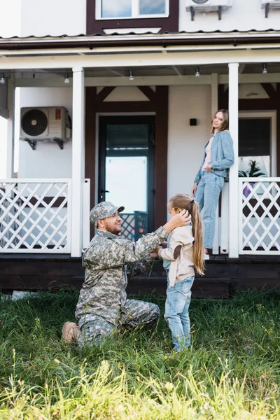 Military Man Sitting Knee Putting Flower Girl Ear Backyard Blurred — Stock Photo, Image