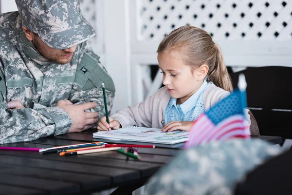 Ojciec Mundurze Wojskowym Siedzi Obok Córki Rysując Kolorowymi Ołówkami Domu — Zdjęcie stockowe