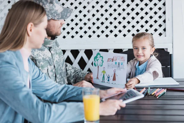 Smiling Girl Picture Looking Camera Sitting Table Blurred Woman Man — Stock Photo, Image