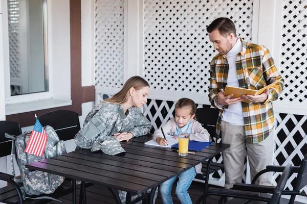 Daughter Writing Notebook While Sitting Attentive Parents — Stock Photo, Image