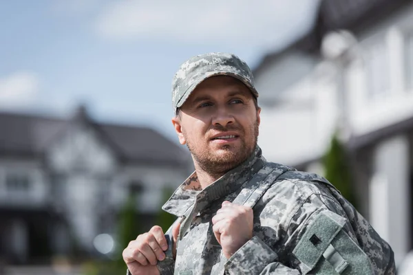 Zelfverzekerde Militair Die Wegkijkt Rugzak Schouderriemen Vasthoudt Met Wazige Buurt — Stockfoto