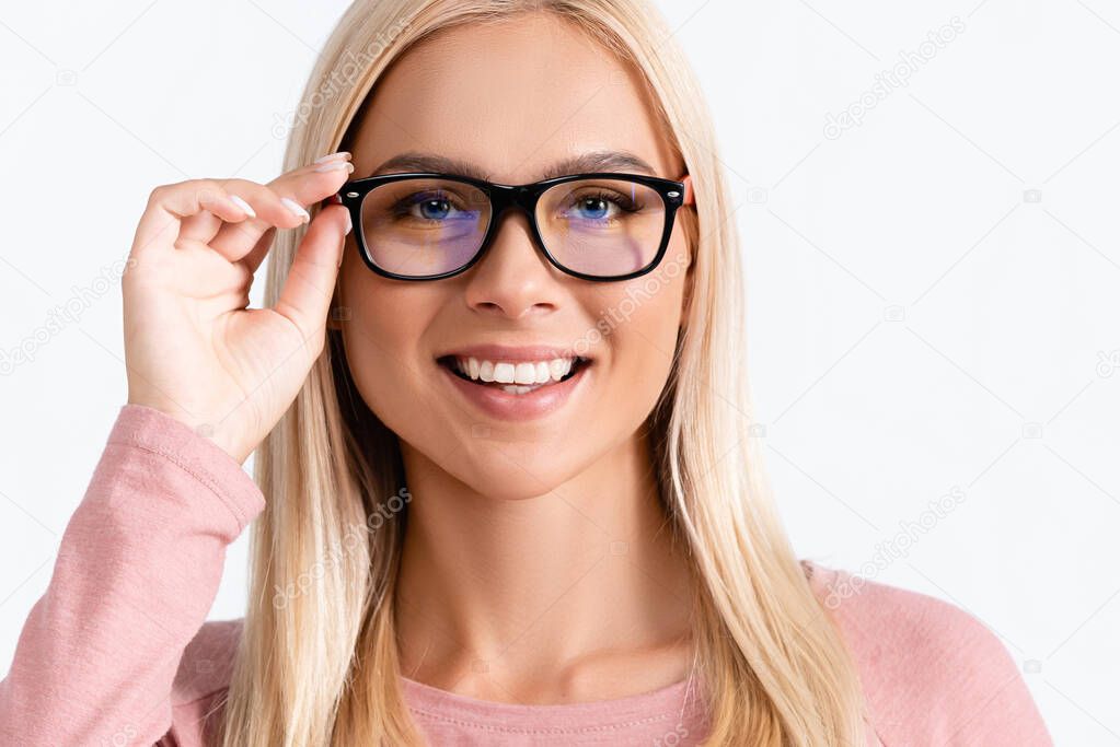 Portrait of blonde happy blonde woman holding eyeglasses frame, while looking at camera isolated on white