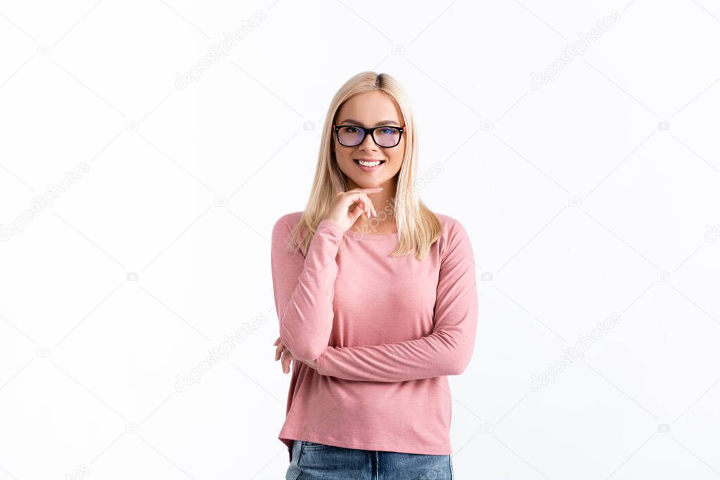 Blonde woman in eyeglasses with hand near chin looking at camera isolated on white
