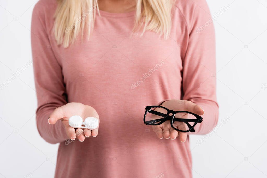 Cropped view of woman holding box with contact lenses and eyeglasses isolated on grey