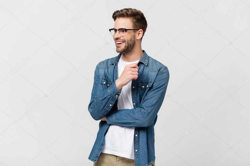 Cheerful man in denim shirt and eyeglasses looking away isolated on grey