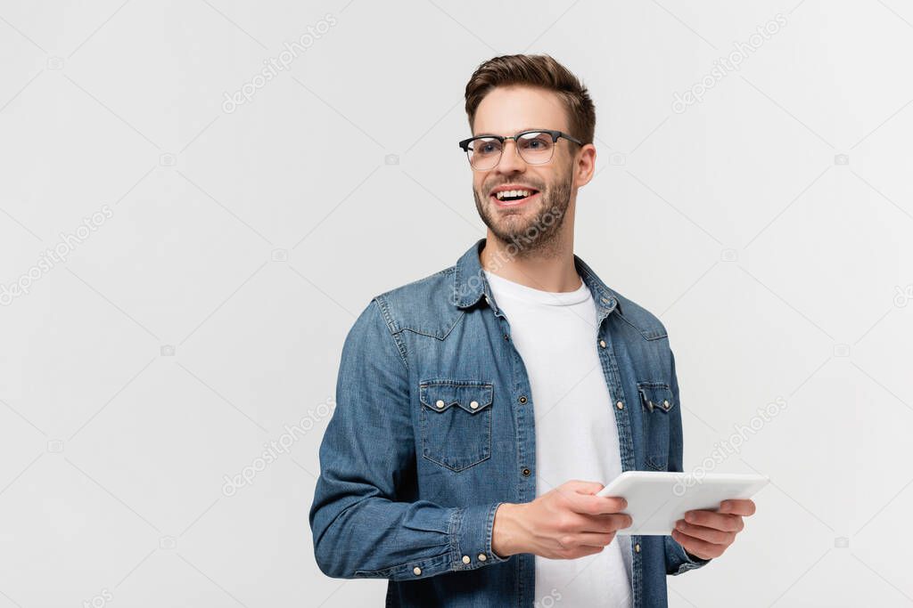 Smiling man in eyeglasses holding digital tablet isolated on grey