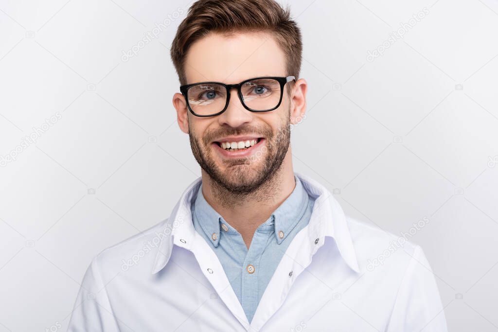 Smiling doctor in eyeglasses looking at camera isolated on grey 