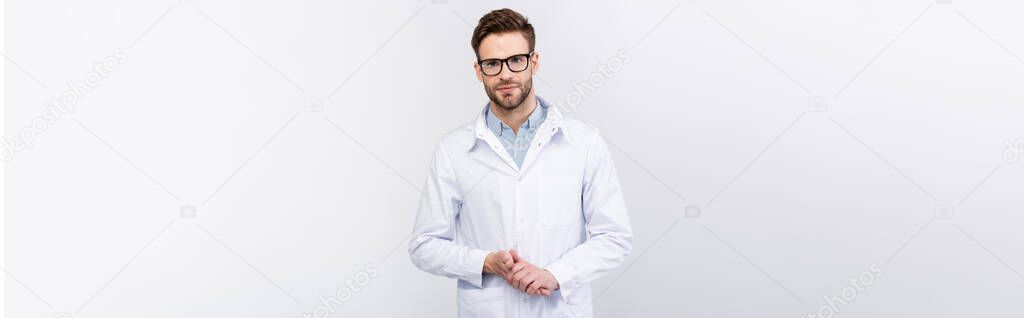 Confident doctor in eyeglasses and white coat isolated on grey, banner 