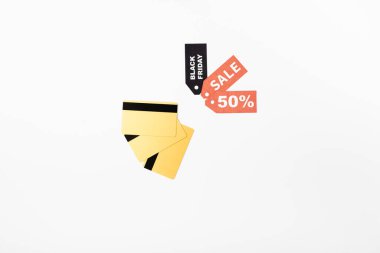 Top view of credit cards and price tags with black friday and sale lettering on white background clipart