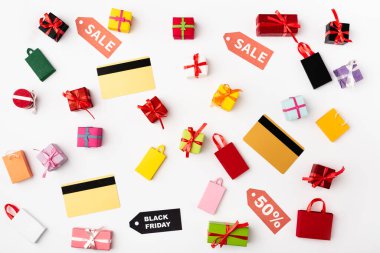 Top view of credit cards with price tags and toy shopping bags on white background clipart